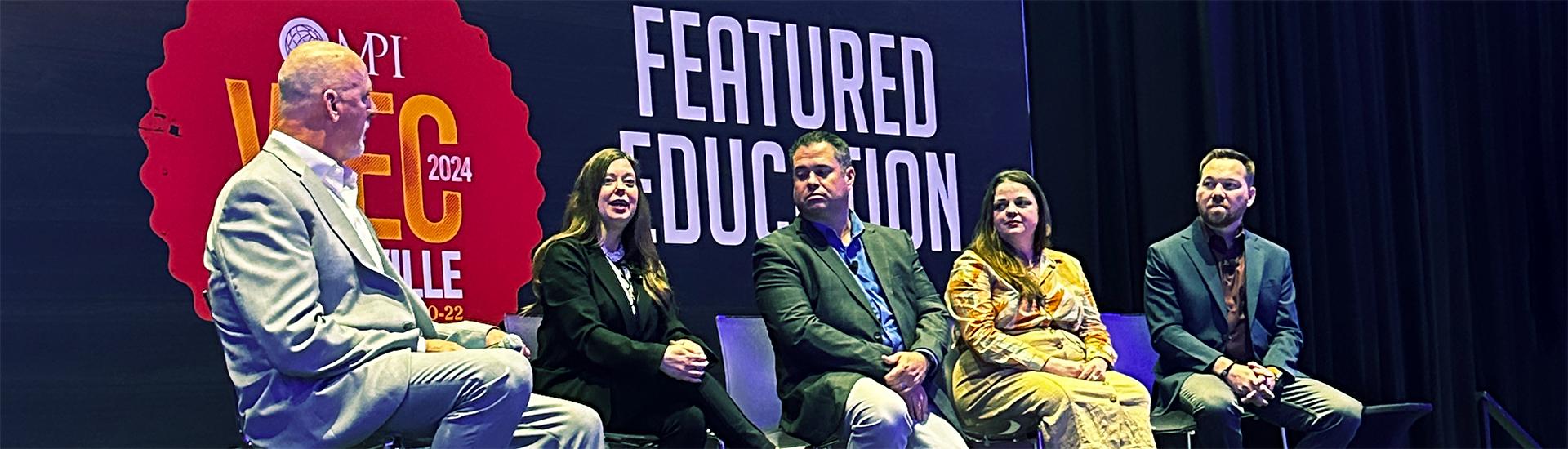 Five people sit on stage in front of a backdrop with the text MPI WEC 2024 Louisville and Featured Education, participating in a panel discussion.